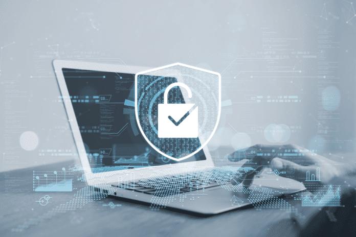 Shield and lock image with a man using a laptop on the background.